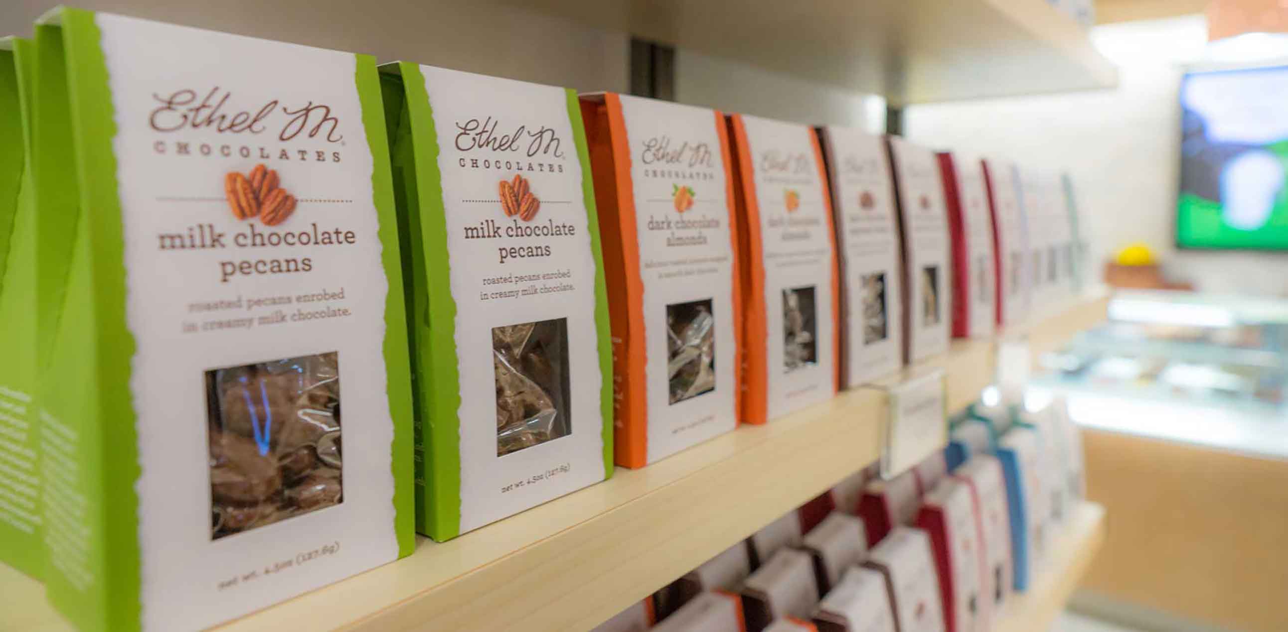 Chocolate boxes lined up on a store shelf